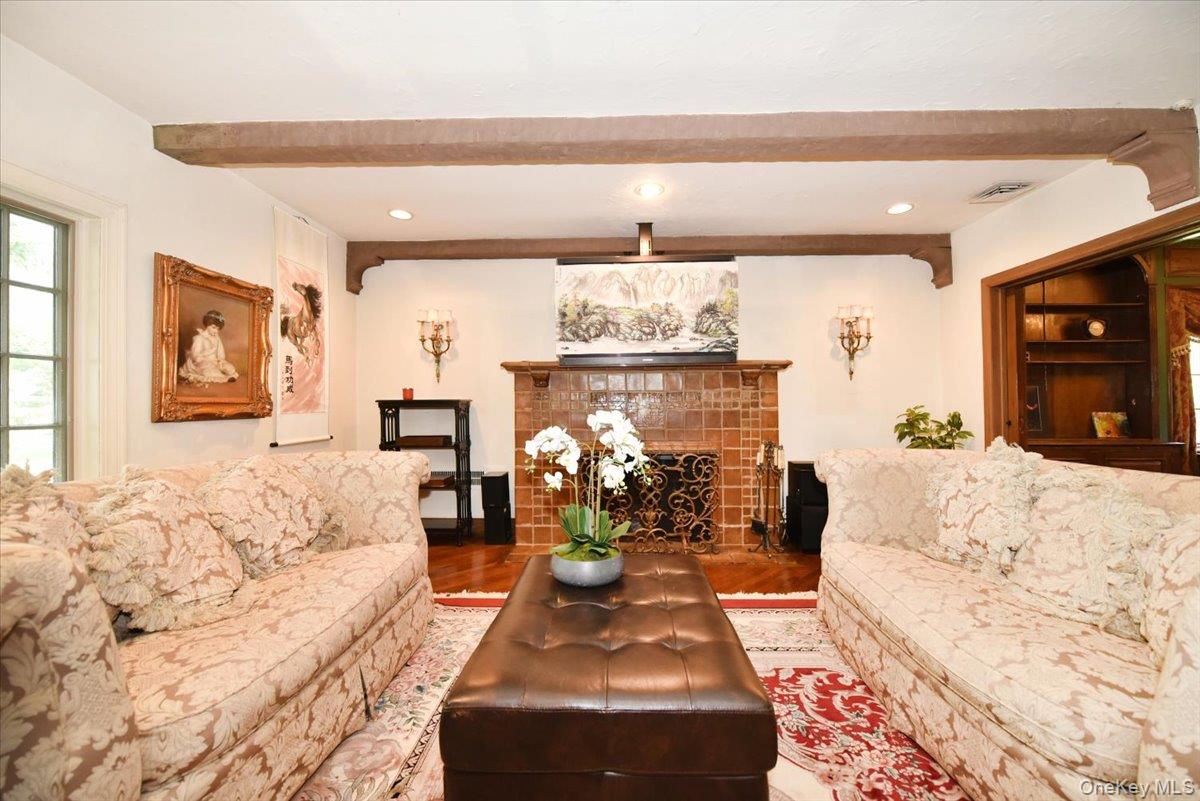 1 Linford Road Great Neck, NY 11021 - Photo 6 of 23 Living area featuring wood finished floors, recessed lighting, a tiled fireplace, and beamed ceiling