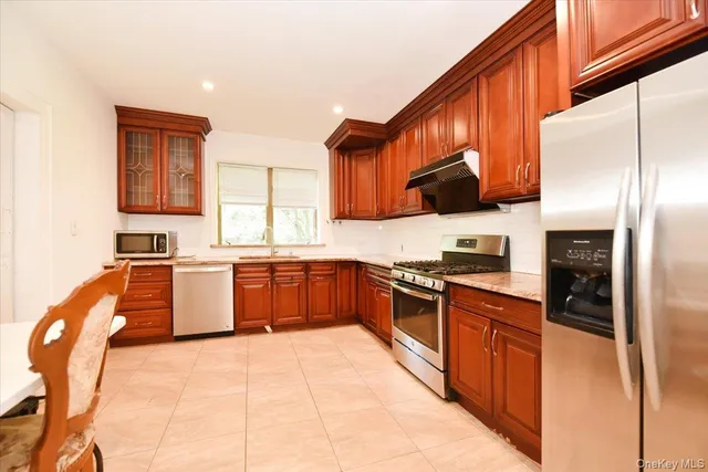 a kitchen with stainless steel appliances granite countertop a stove a sink dishwasher and a refrigerator