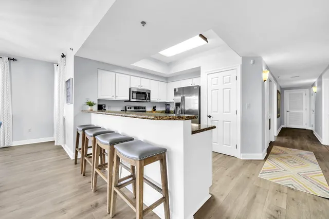 a kitchen with granite countertop a refrigerator and a stove top oven