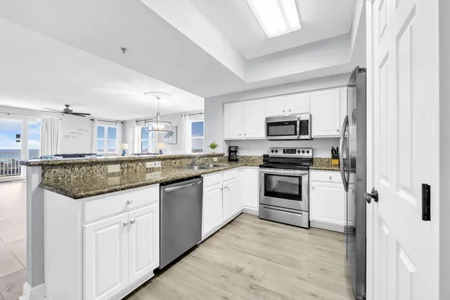 a kitchen with stainless steel appliances granite countertop a refrigerator a stove and a sink