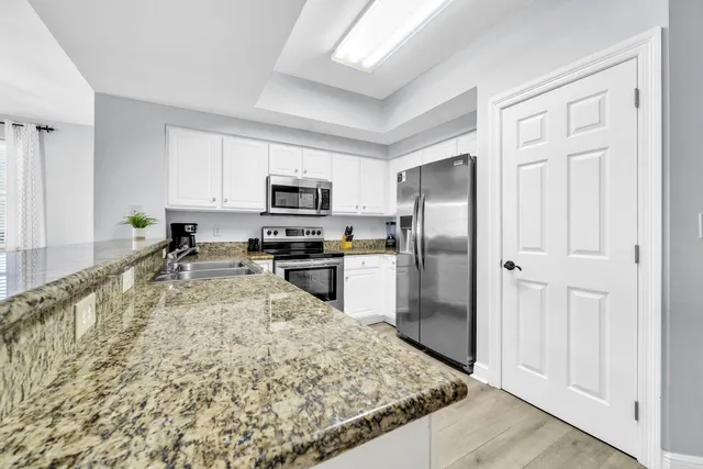 a bedroom with a bed and a flat tv screen on dresser