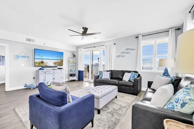 a living room with furniture kitchen view and a window