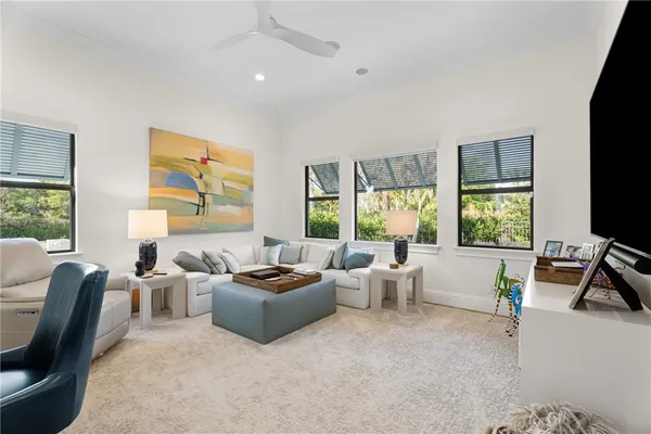 a living room with furniture flat screen tv and a large window