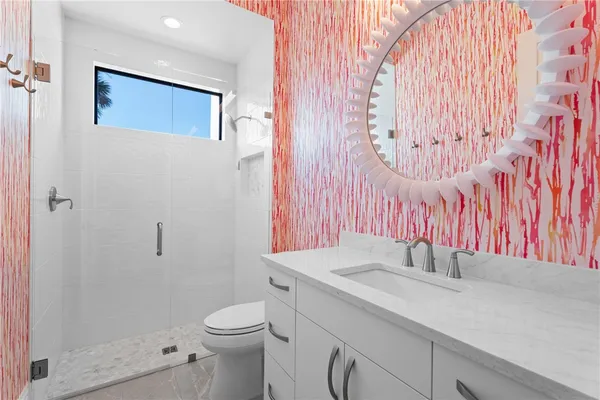 a bathroom with a sink a toilet and shower