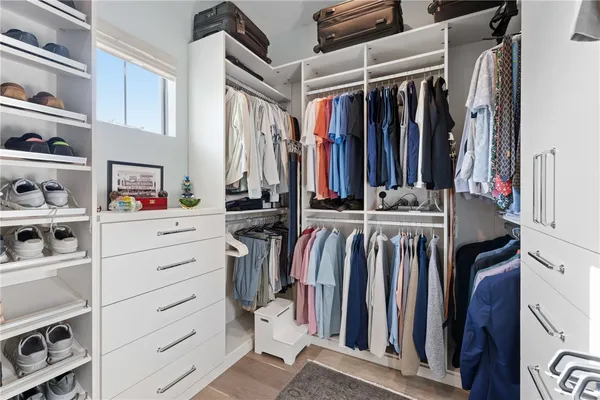 a view of walk in closet with clothes and shoes