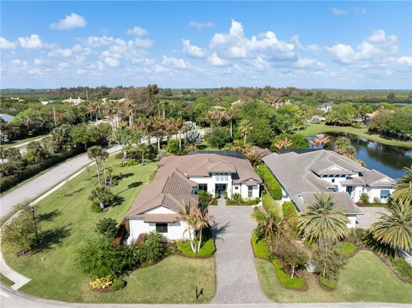 an aerial view of residential houses with outdoor space and trees