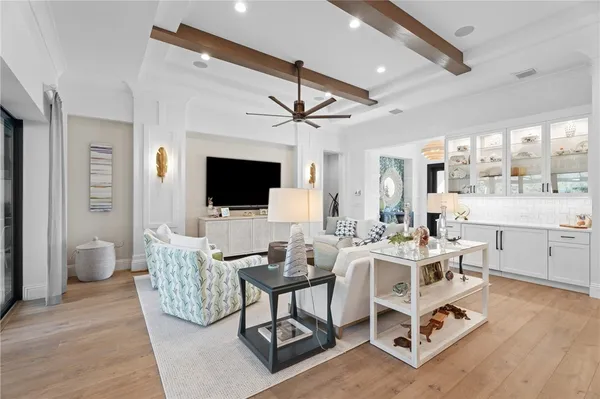 a living room with furniture a flat screen tv and a floor to ceiling window