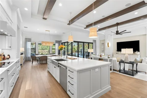 a large white kitchen with a large window and furniture