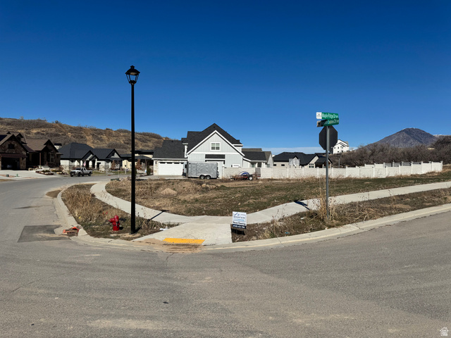 3583 South Mapleton Drive, Unit 13 Mapleton, UT 84664 - Photo 5 of 14 View of asphalt road featuring sidewalks, street lighting, curbs, a residential view, and a mountain view