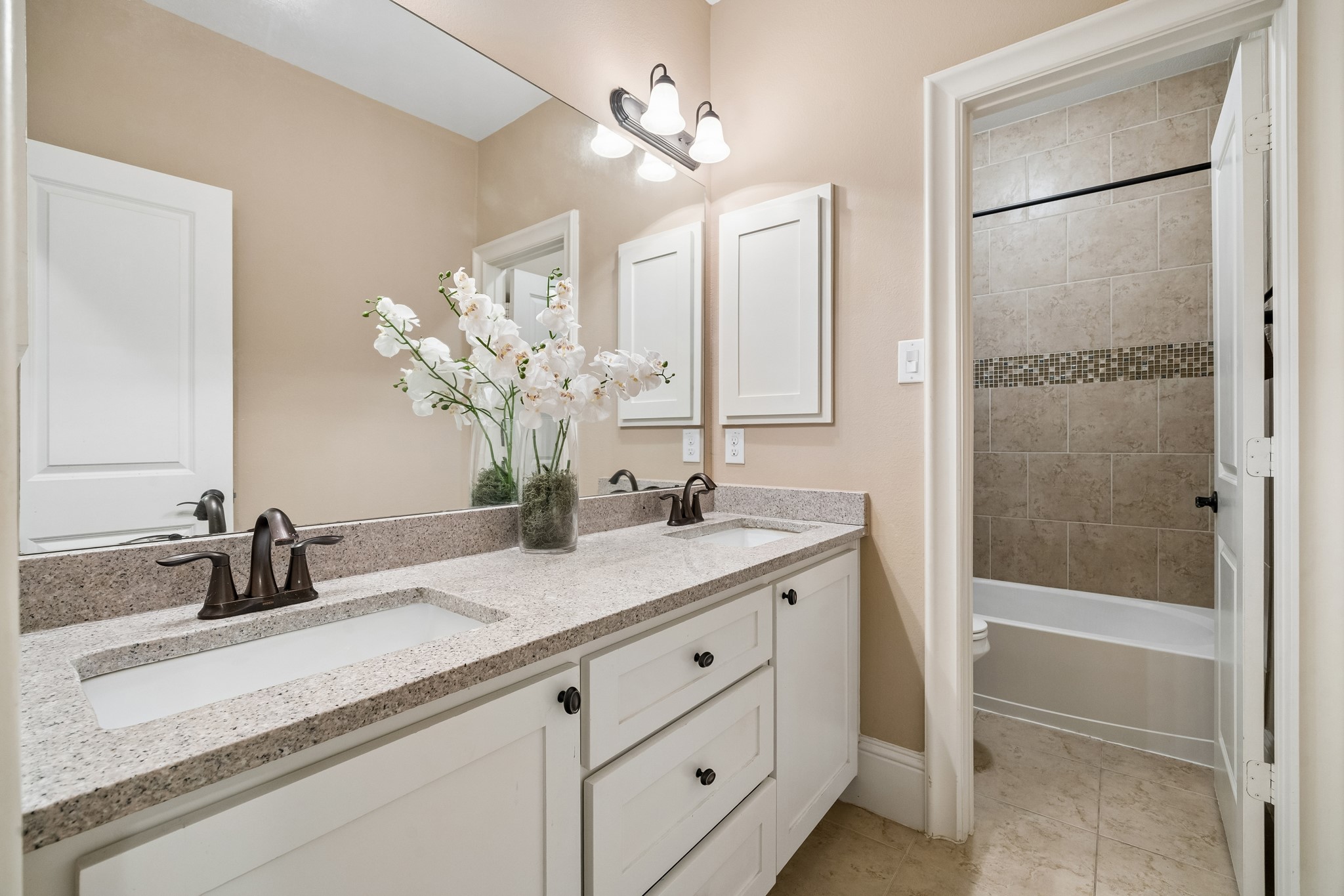 1360 Chippendale Road Houston, TX 77018 - Photo 24 of 34 Spacious secondary bath ideally positioned between secondary bedrooms #2 and #3. Features dual sinks, granite countertops, generous vanity storage, and a separate tub/shower and toilet area for added functionality. Conveniently located adjacent to the second-floor utility room.