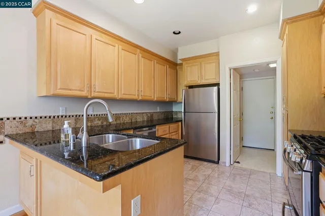 a kitchen with stainless steel appliances granite countertop a refrigerator and a sink
