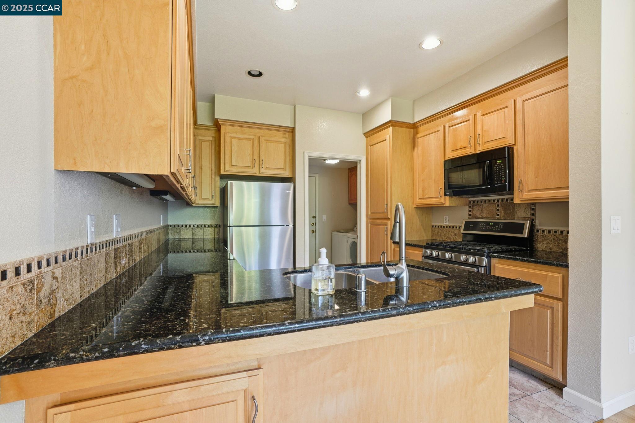 1295 Shell Circle Clayton, CA 94517 - Photo 10 of 36 a kitchen with stainless steel appliances granite countertop a sink a stove and a refrigerator