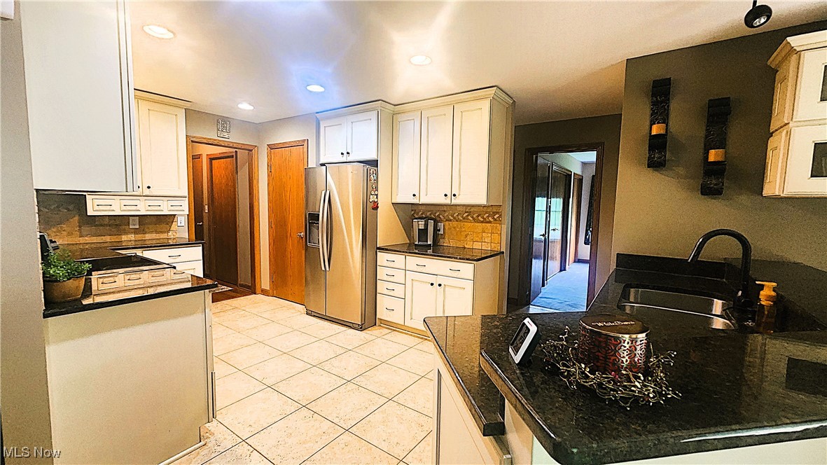 8329 Seasons Road Streetsboro, OH 44241 - Photo 6 of 35 Kitchen with stainless steel fridge, light tile patterned floors, sink, and decorative backsplash