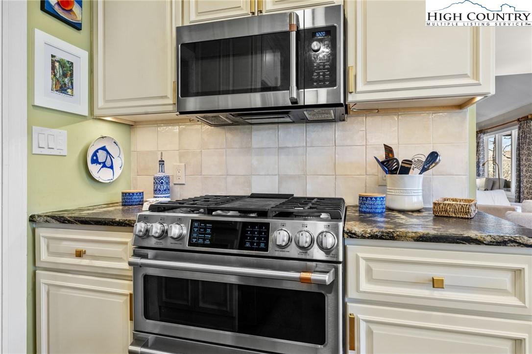 129 Valley View Road Blowing Rock, NC 28605 - Photo 11 of 45 a kitchen with stainless steel appliances granite countertop a stove and a microwave