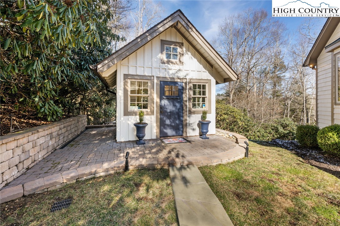 129 Valley View Road Blowing Rock, NC 28605 - Photo 38 of 45 a view of a white house with large trees and plants next to a yard