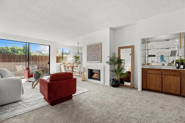 a living room with furniture a fireplace and a large window