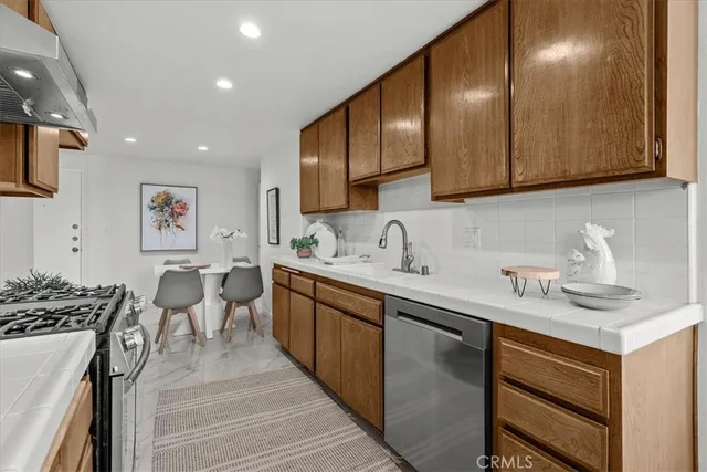 a kitchen with stainless steel appliances granite countertop a sink stove and cabinets