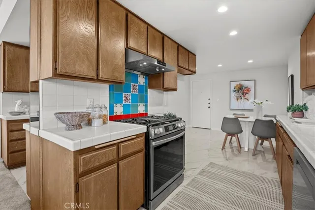 a kitchen with a stove cabinets and wooden floor