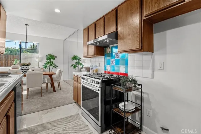 a kitchen with stainless steel appliances granite countertop a stove a sink dishwasher and cabinets with wooden floor