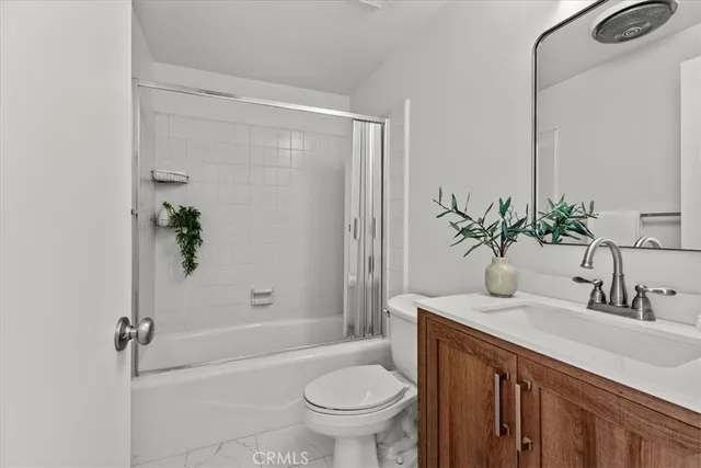 a bathroom with a granite countertop sink a toilet and shower