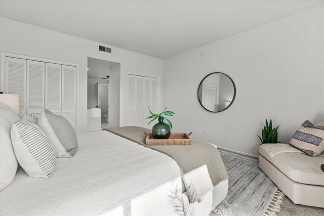 a bedroom with a bed a mirror and a chandelier