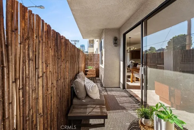 a view of a balcony with chairs and potted plants