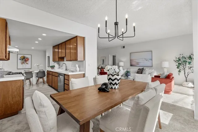 a view of a dining room and livingroom with furniture wooden floor a chandelier