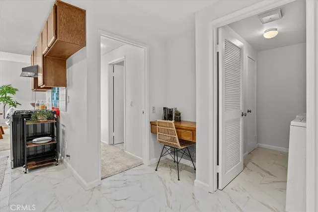 a view of a hallway with a livingroom and a chair