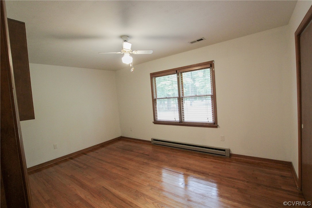 1120 Mill Road King William, VA 23086 - Photo 19 of 40 an empty room with wooden floor chandelier fan and windows