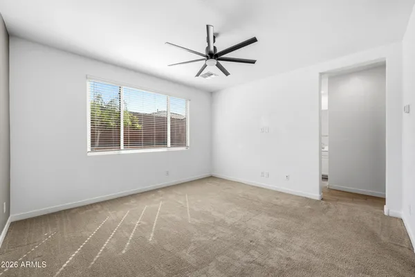 an empty room with closet and ceiling fan
