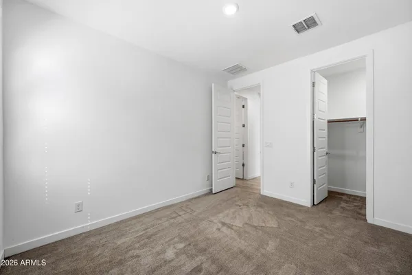 an empty room with closet and windows