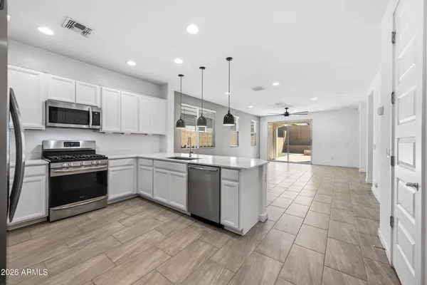 a large kitchen with a large counter top appliances and cabinets