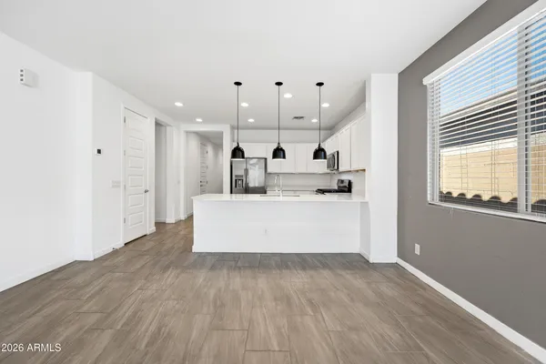 a large kitchen with stainless steel appliances lots of white cabinets