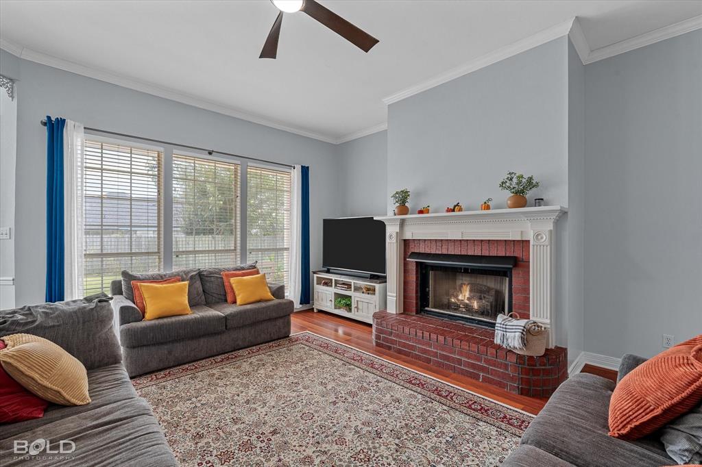 6020 Applegate Circle Bossier City, LA 71111 - Photo 15 of 36 a living room with a couch a fireplace and a floor to ceiling window