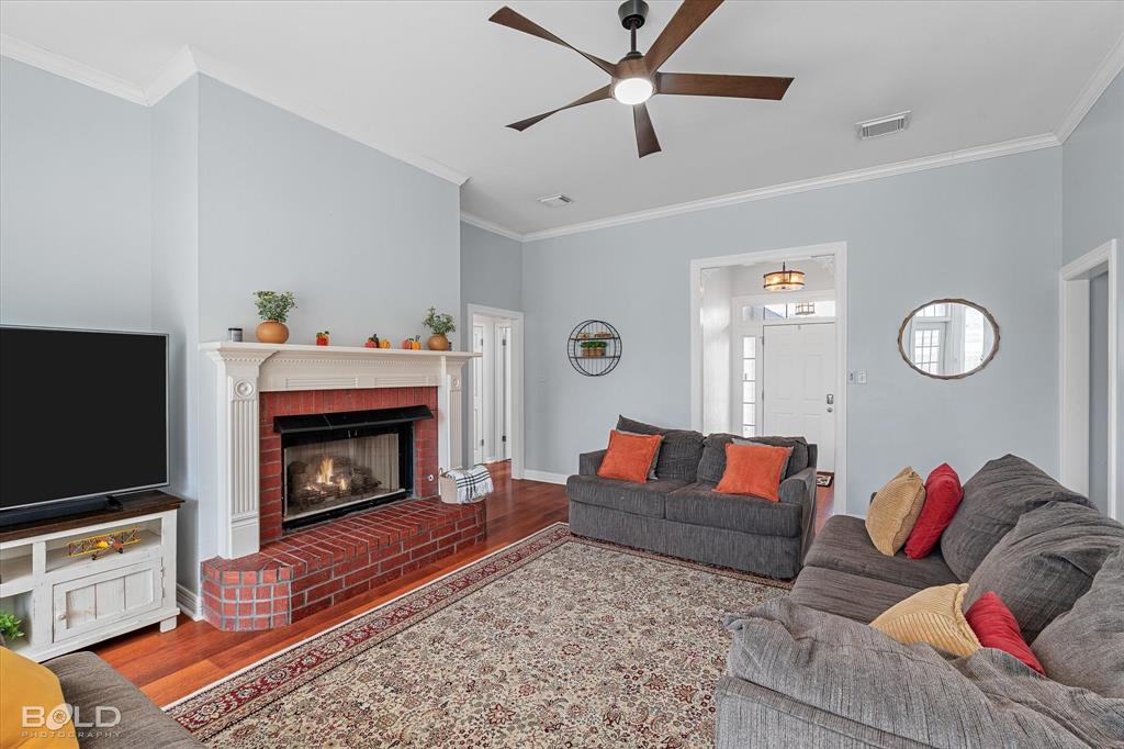 6020 Applegate Circle Bossier City, LA 71111 - Photo 19 of 36 a living room with furniture a flat screen tv and a fireplace