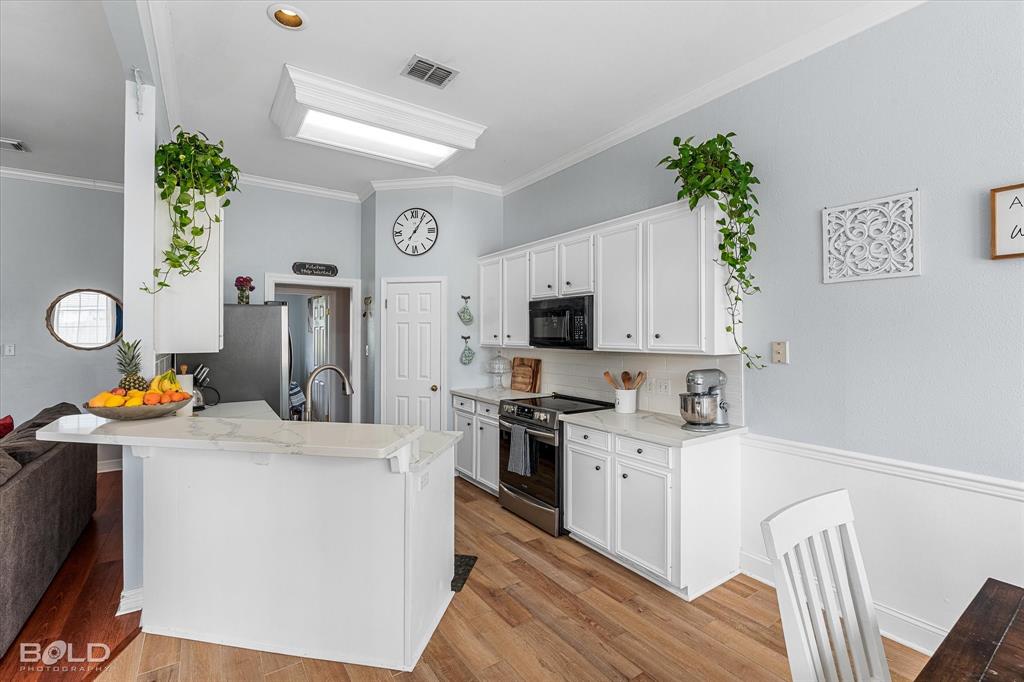 6020 Applegate Circle Bossier City, LA 71111 - Photo 21 of 36 a kitchen that has a lot of cabinets a sink and a stove