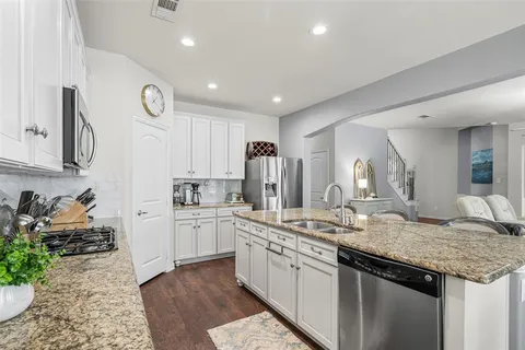 a kitchen with sink stove and refrigerator