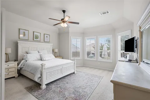 a spacious bedroom with a large bed and a flat screen tv