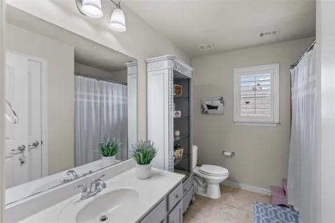 a bathroom with a granite countertop toilet a sink and a mirror
