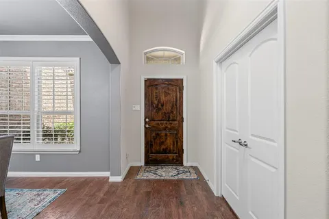 a view of a hallway with wooden floor and a livingroom