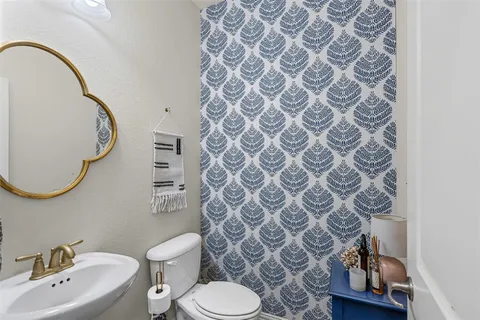 a bathroom with a toilet sink and mirror