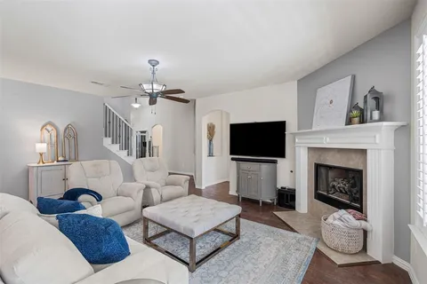 a living room with furniture a flat screen tv and a fireplace
