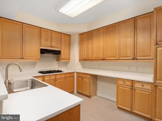 a kitchen with stainless steel appliances granite countertop a sink a stove and cabinets