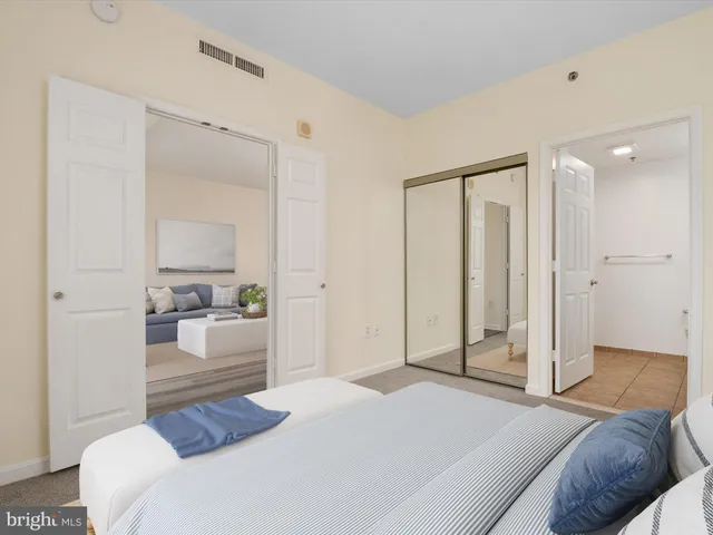 a bedroom with a bed and a large mirror