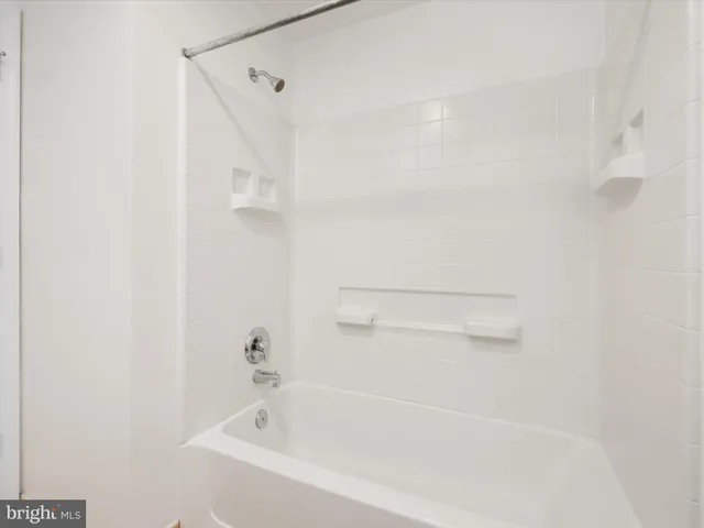 a white bath tub sitting next to a shower