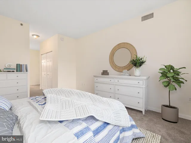 a bedroom with a bed and a potted plant