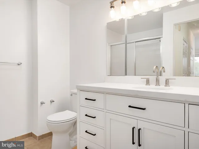 a bathroom with a sink vanity mirror and toilet