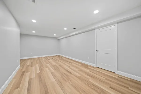 a view of empty room with wooden floor