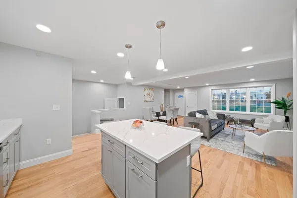 a view of a kitchen with kitchen island a sink a counter top space and living room view