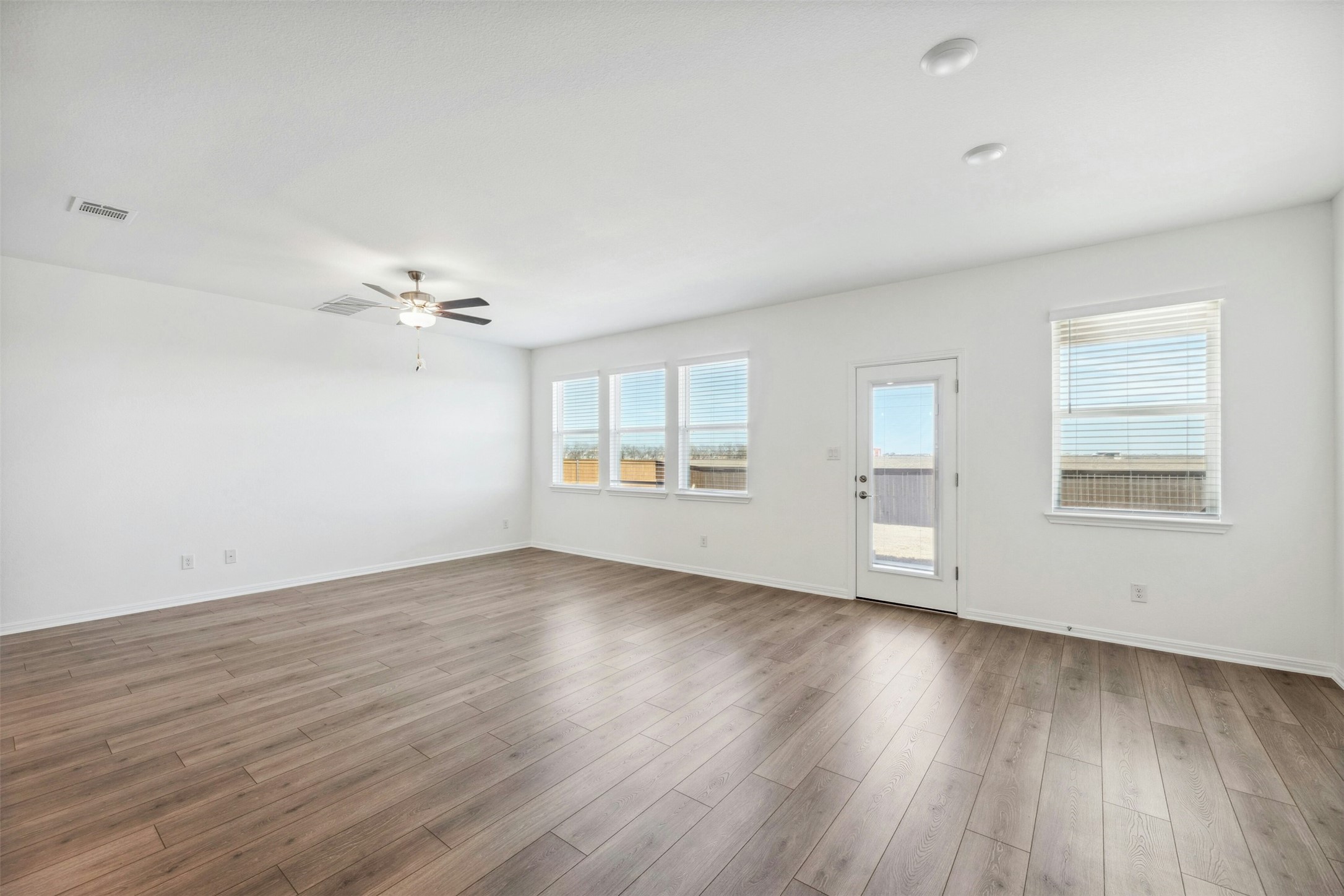 2001 Wynn Road Hutto, TX 78634 - Photo 6 of 39 A well-lit open space with attractive wood flooring and ample natural light, creating an inviting atmosphere.